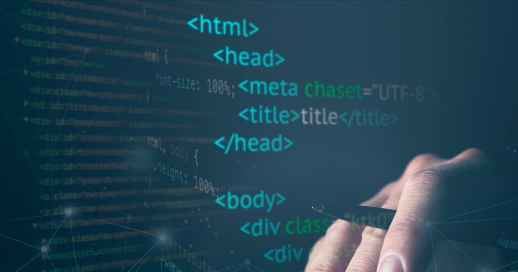 Mano escribiendo código HTML en un ordenador, ilustrando la personalización de Bootstrap en un proyecto Laravel 11